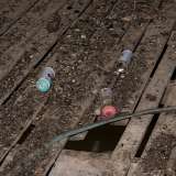 Torniamo verso la rampa per avanzare al terzo piano, dove tra un tappeto di vetri rotti, chiodi, tubi di gomma e pezzi di intonaco balzano all'occhio delle bombolette spray usate